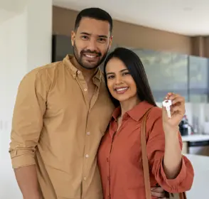 Pareja feliz recibiendo las llaves de su apartamento nuevo
