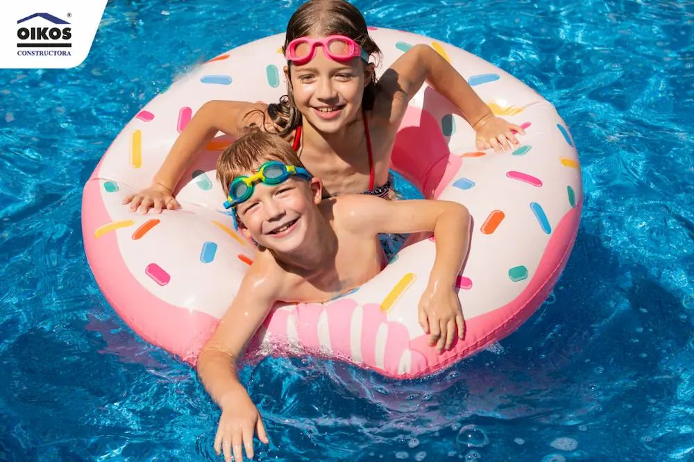Niños en piscina nadando con flotador de dona