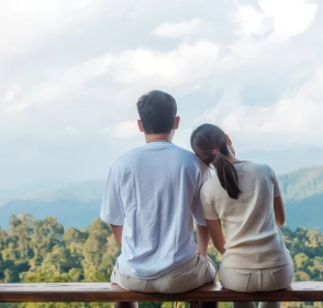 Pareja feliz viendo el paisaje en un balcón