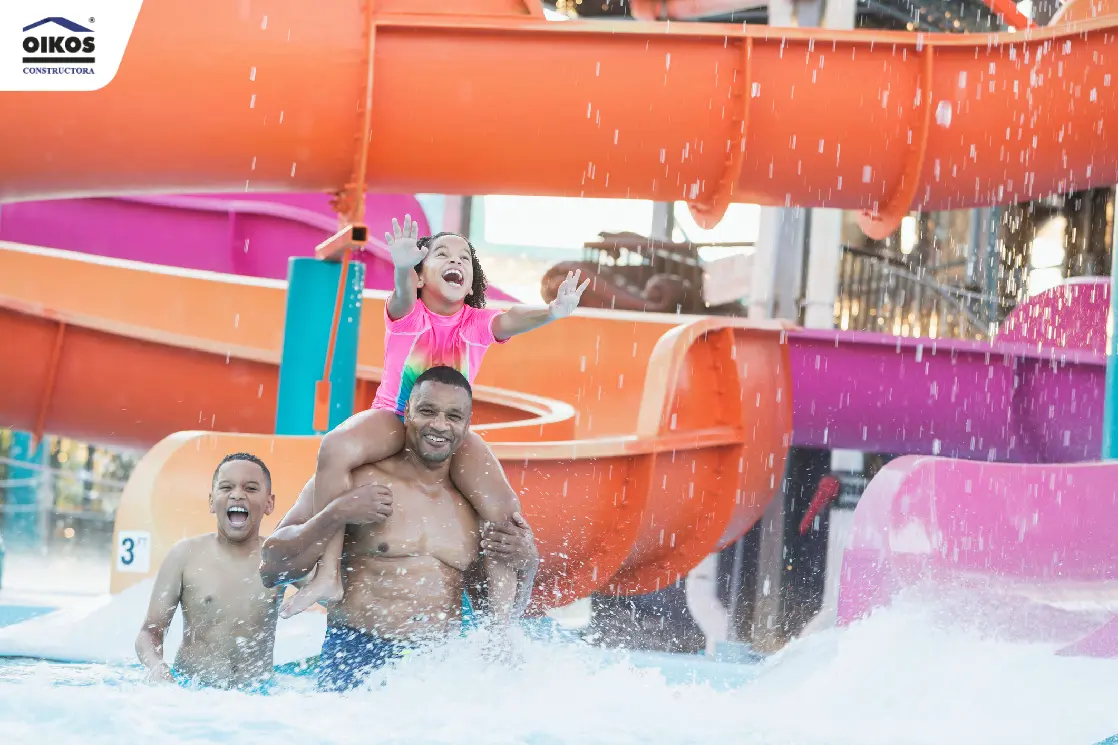 El placer de vivir en un paraíso de clima cálido como Girardot Familia feliz en los toboganes de una piscina