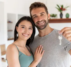 Pareja con las llaves de su vivienda nueva