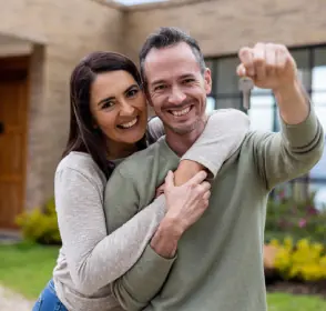 Pareja feliz con las llaves de su nueva casa
