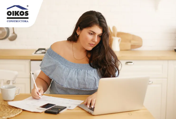Persona organizando sus finanzas y creando un presupuesto frente a un computador
