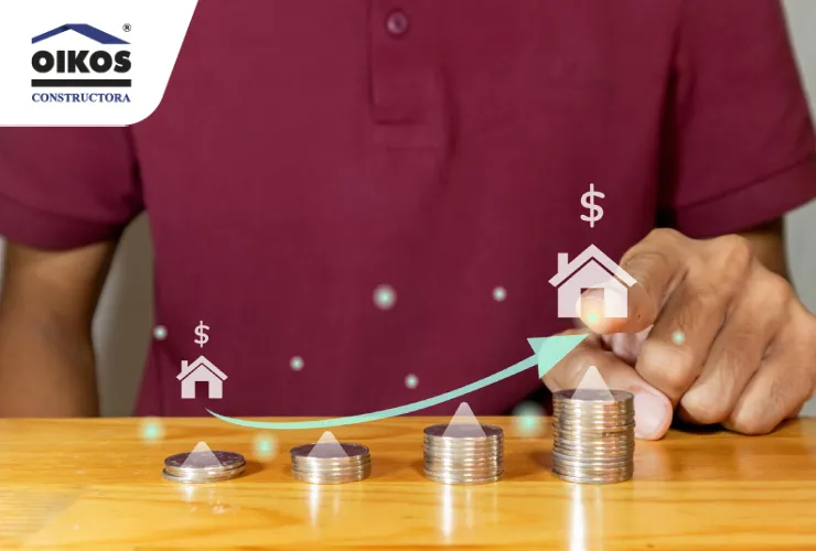 ¿Es rentable comprar vivienda para arrendar en Colombia? Persona señalando una flecha ascendente sobre monedas y casas en miniatura, representando la inversión en vivienda