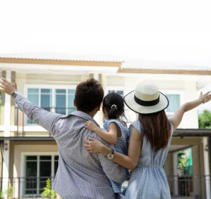 Familia feliz frente a una casa de descanso en Ricaurte