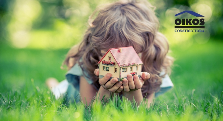 Niña mostrando la idea de una vivienda sostenible